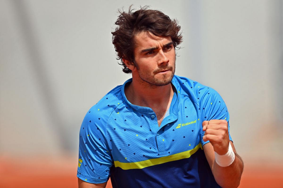 The Spanish wheelchair tennis player Daniel Caverzaschi, wearing a blue shirt, punches the air in celebration