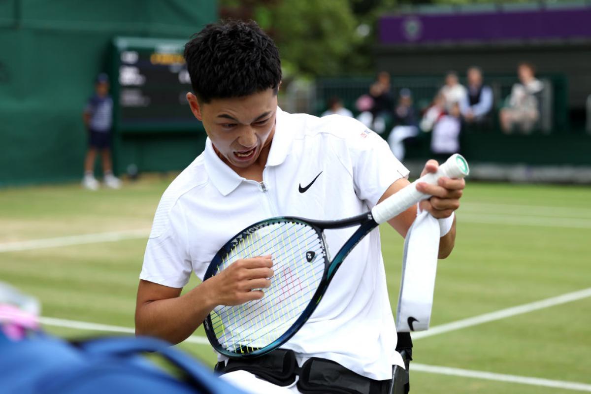 Tokito Oda playing air guitar with his racquet 