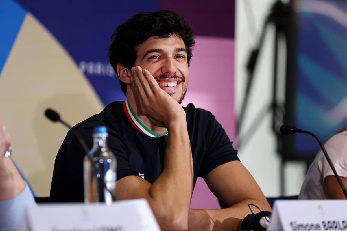 A man with a hand on his face during a press conference