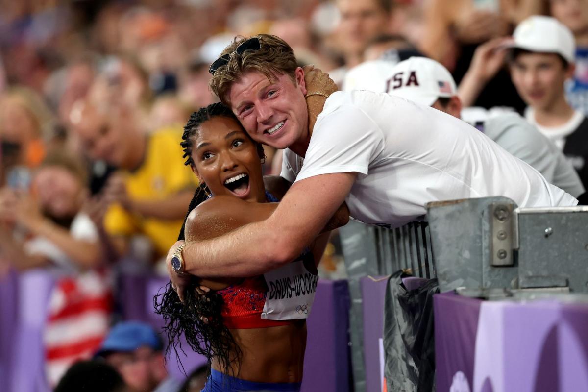 A female athlete hugging a man on trackside