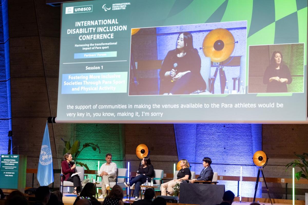 Five persons speaking to the public in a conference