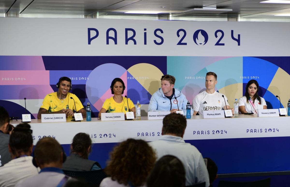 A group of three men and two women in a press conference