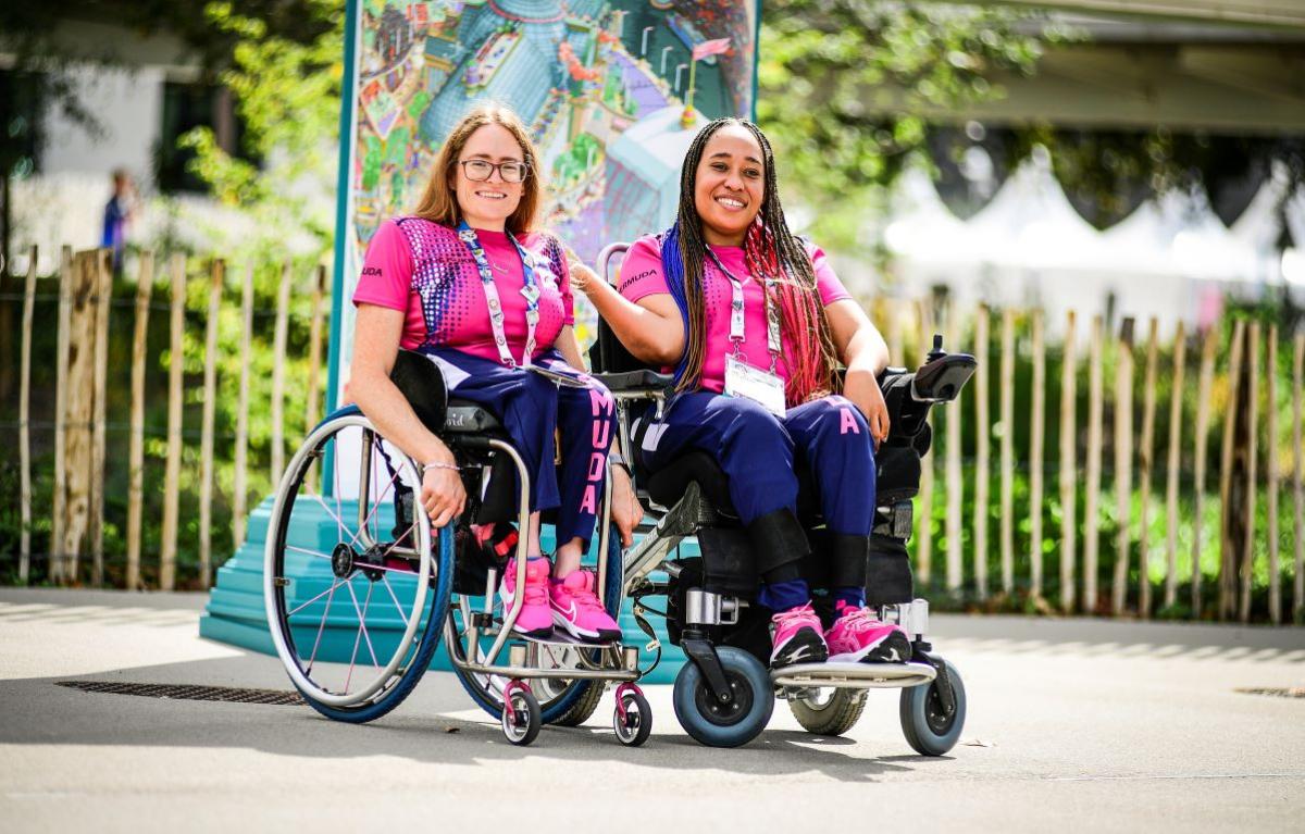 Two female athletes wearing a pink T-shirt pose for a photo
