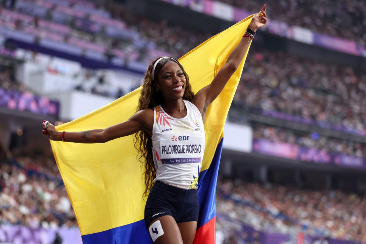 A female athlete with the Colombian flag in a stadium