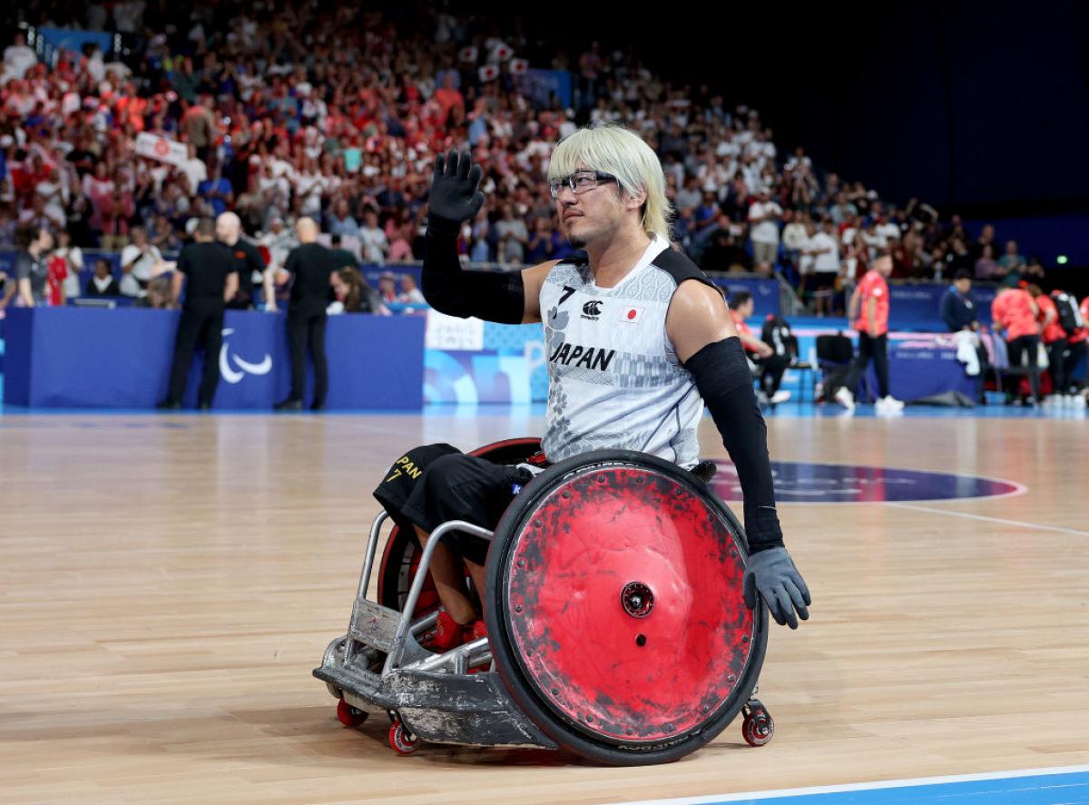 Wheelchair rugby player Daisuke Ikezaki waves to the crowd