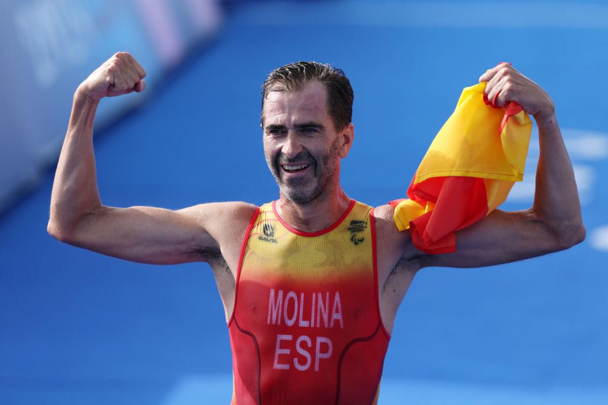 Para triathlete Daniel Molina shows off his biceps at the finish line