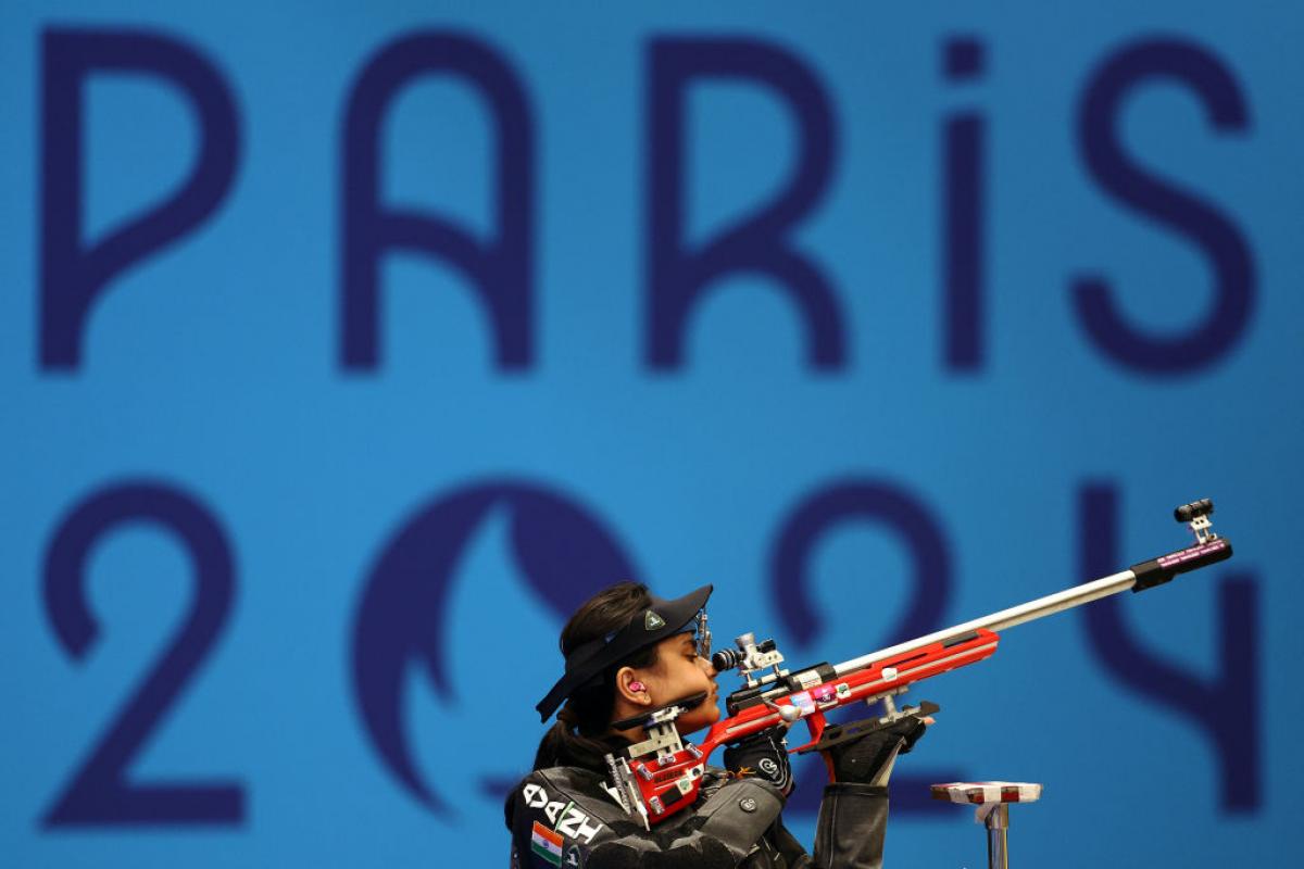 A female shooter with a rifle in a competition at Paris 2024