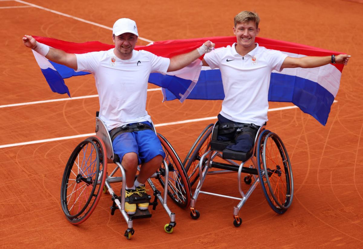 Sam Schroder and Nils Vink holding up Dutch flags