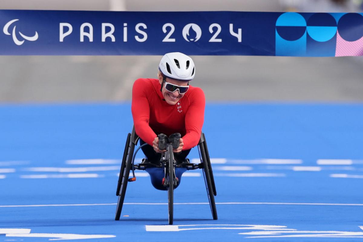 A female wheelchair racer crossing the finish line of the Paris 2024 marathon