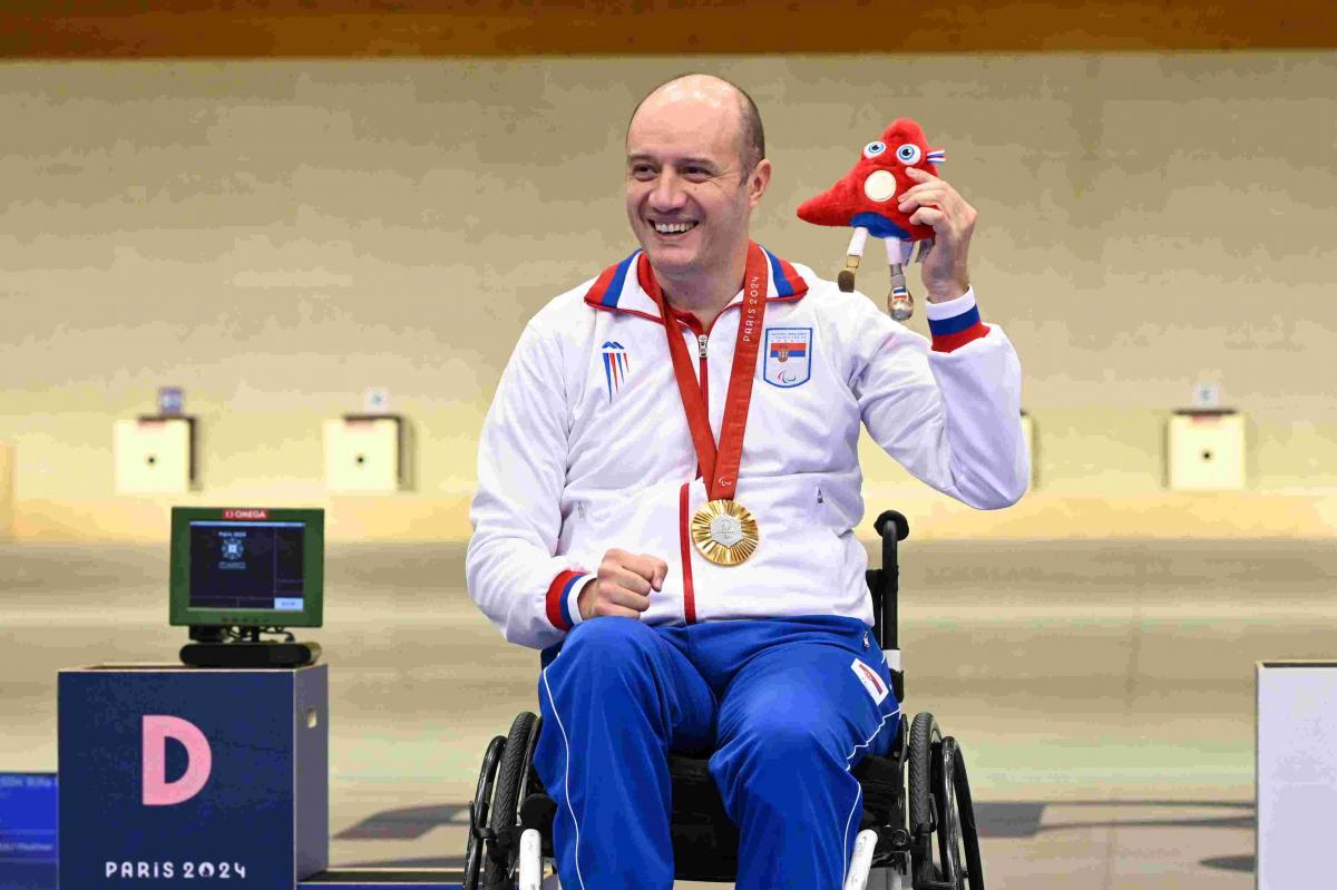An athlete poses on podium