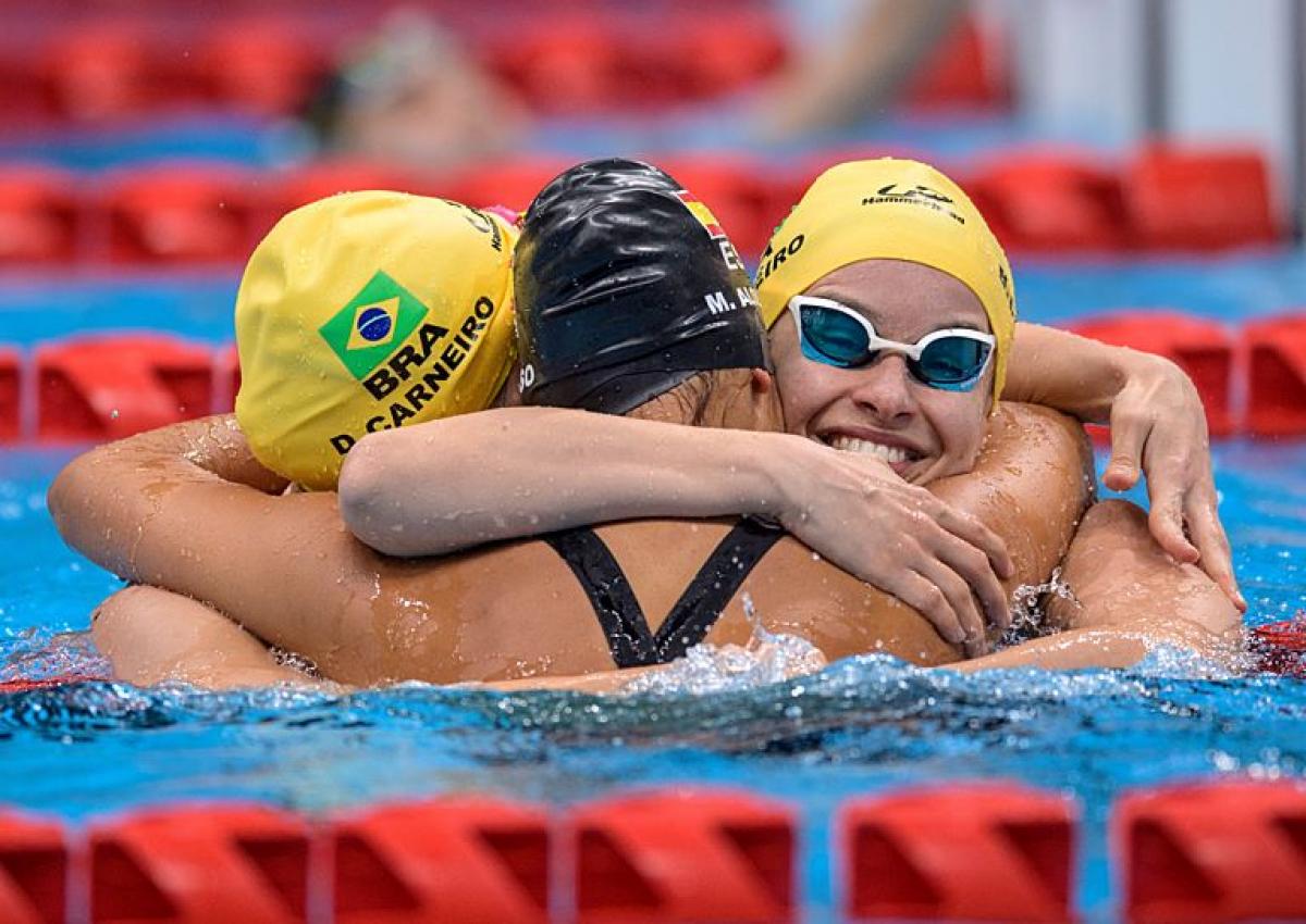Debora and Beatriz Borges Carneiro hug in the pool
