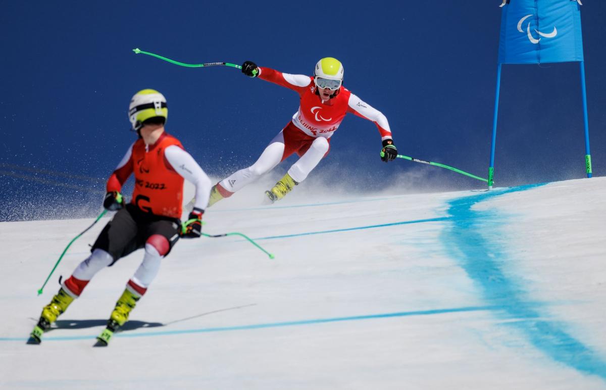 A male alpine skier follows his guide skier during competition