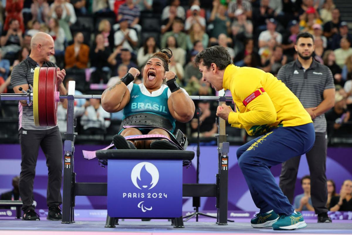 Tayana Medeiros pumps her fist after a successful lift