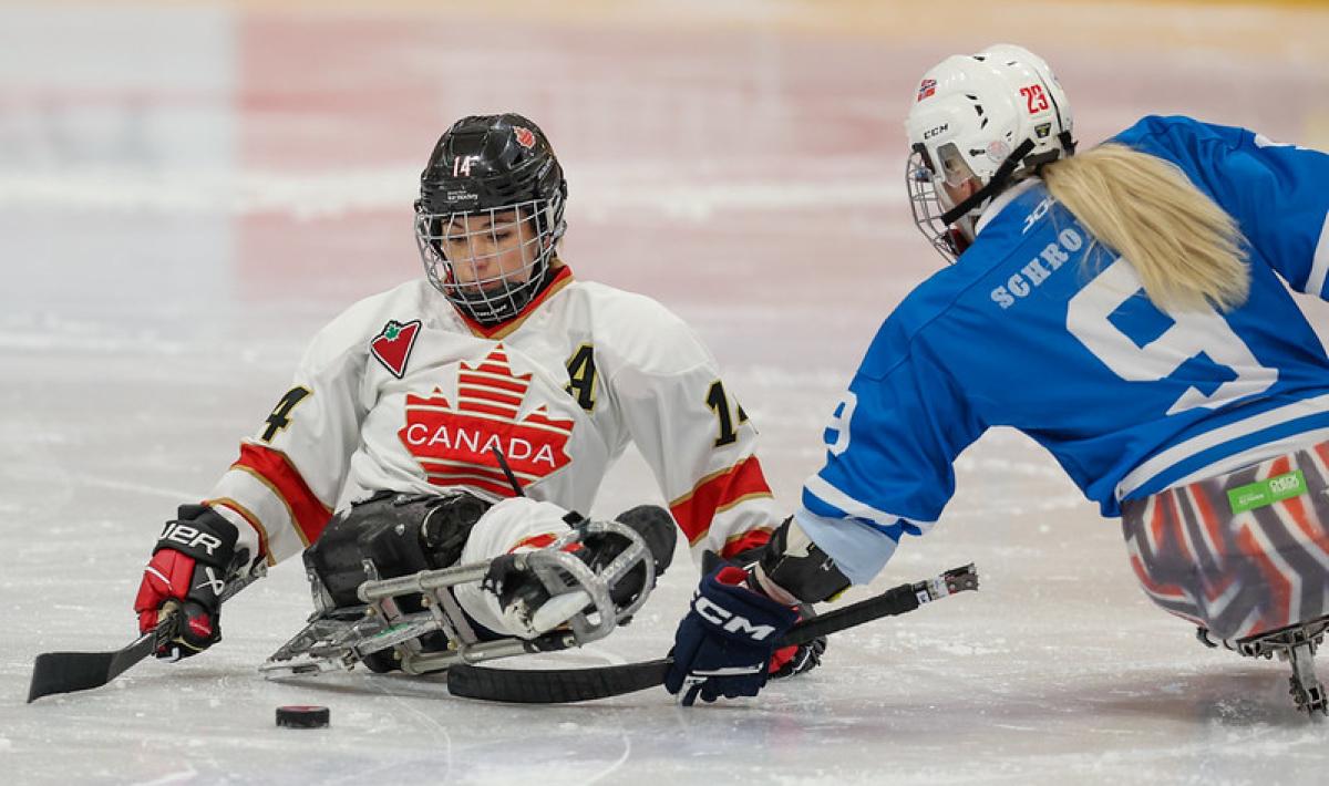 Two female Para ice hockey players in a game
