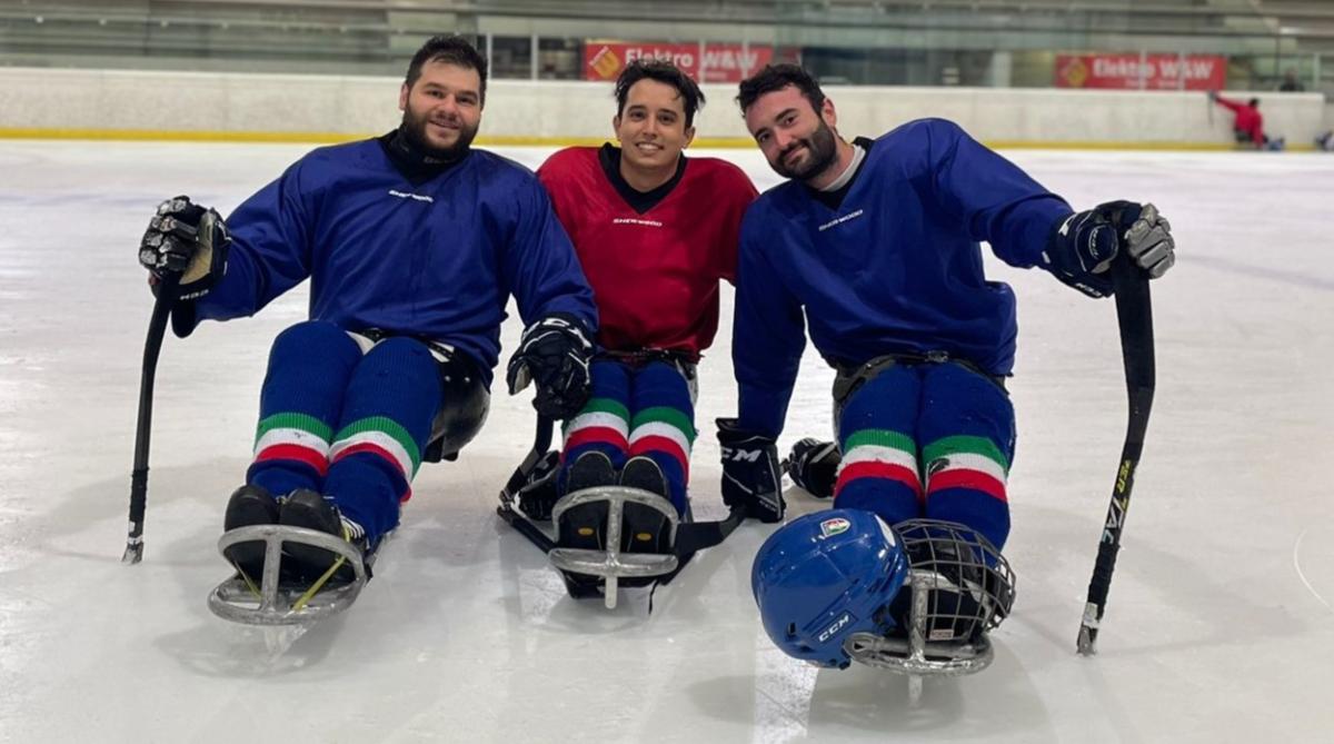 Three male Italian Para ice hockey athletes posing on the ice