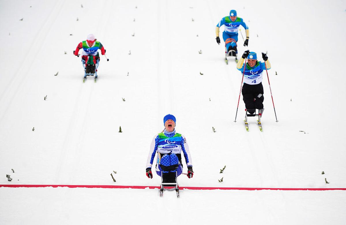 Four Para cross-country sit-skiers in action. Francesca Porcellato, who is in the centre of the image, reacts after crossing the red line