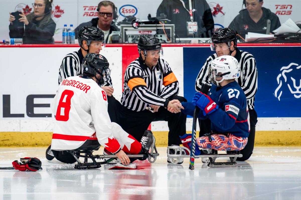 A Para ice hockey official shaking hands with a USA player