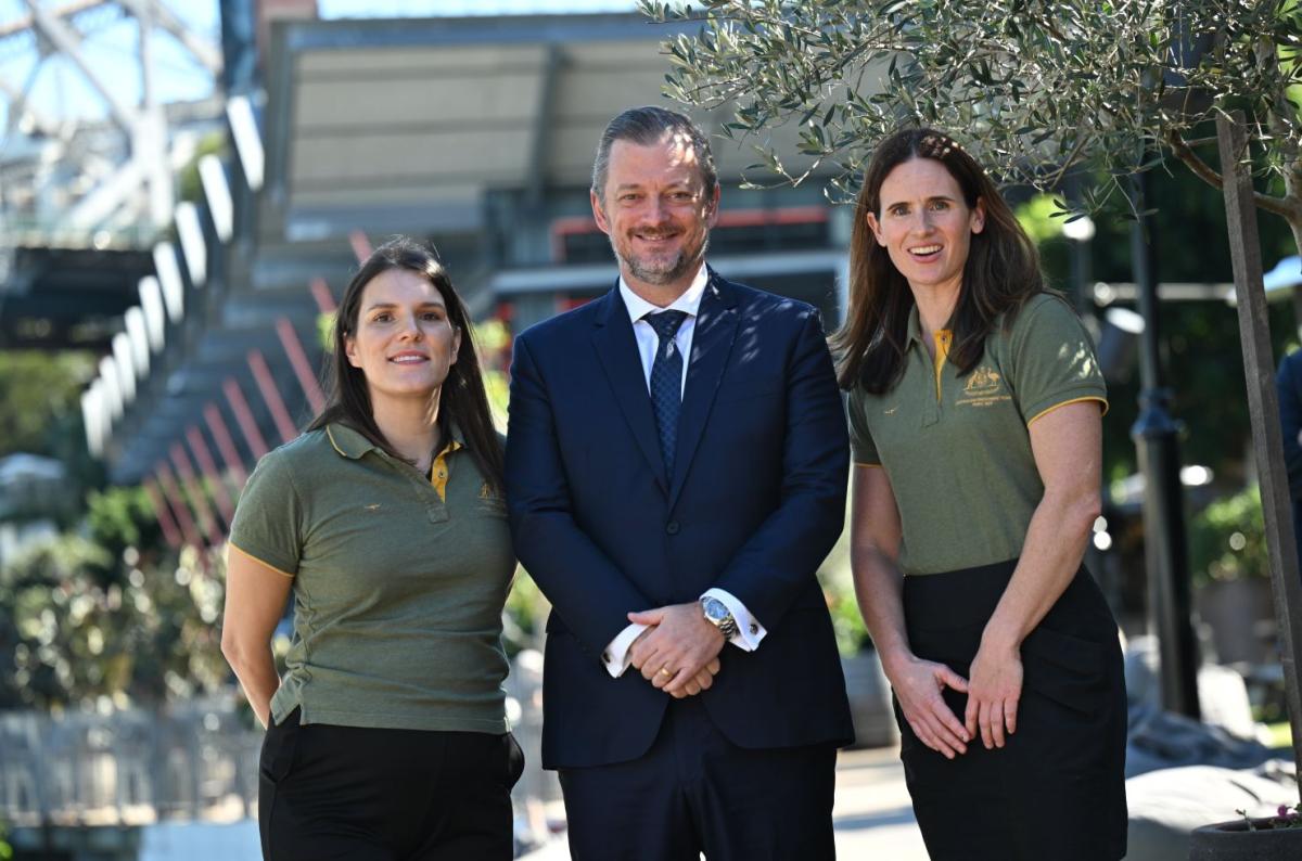 IPC President Andrew Parsons and two female Paralympians wearing Australia's green polo shirt are posing for a photo