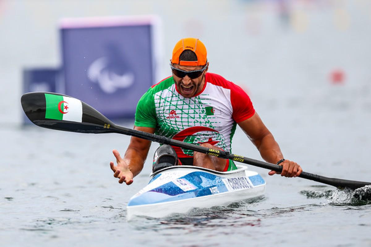 A male Para canoe athlete reacting with a roar after a race