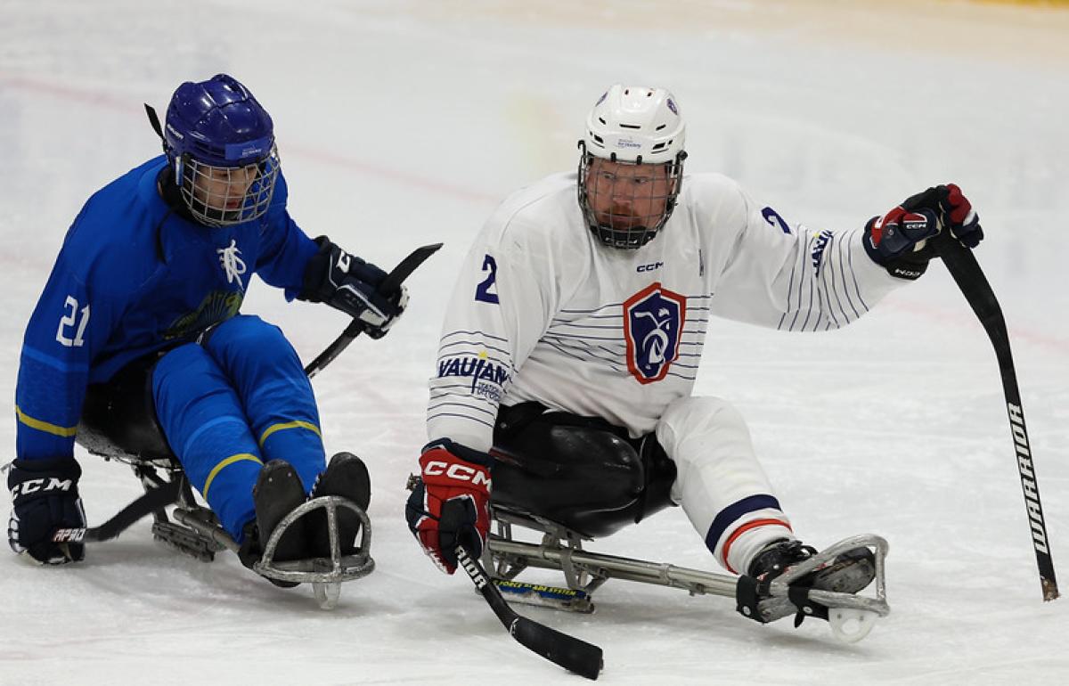 A Kazak and a French Para ice hockey player in a game