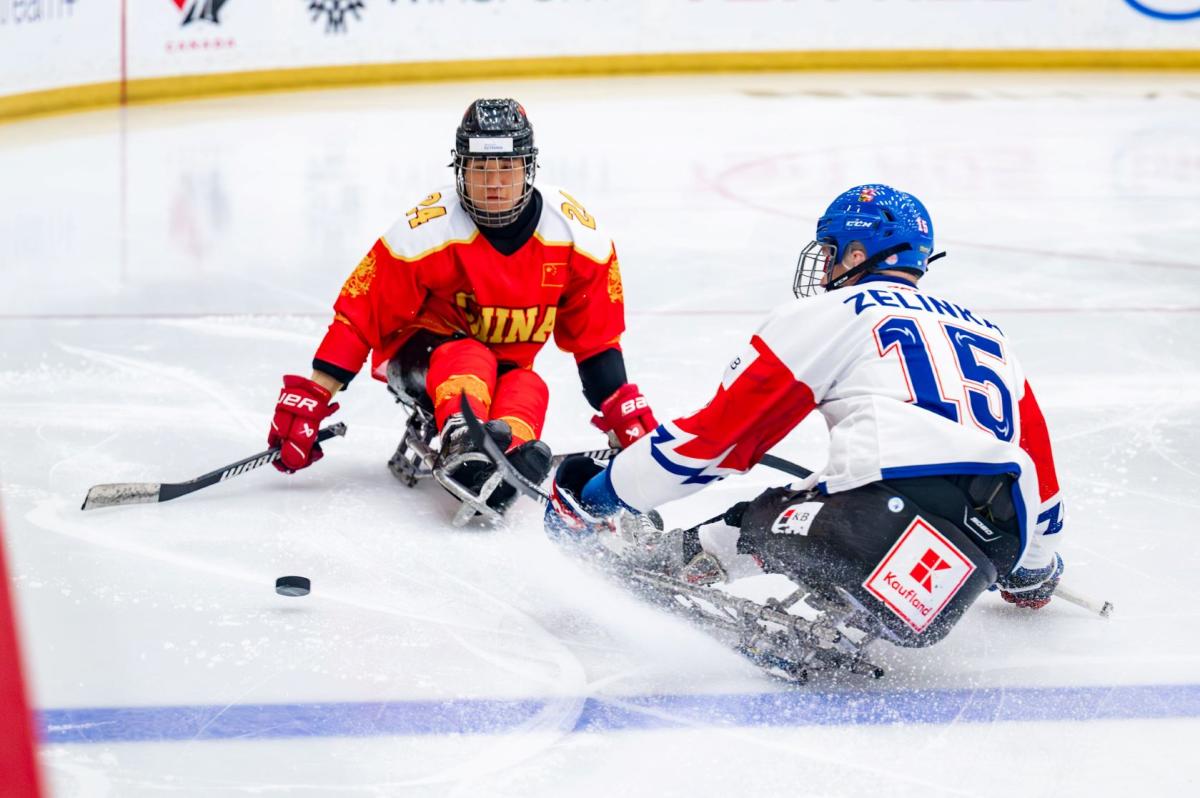 A Chinese Para ice hockey player in front of a Czech player