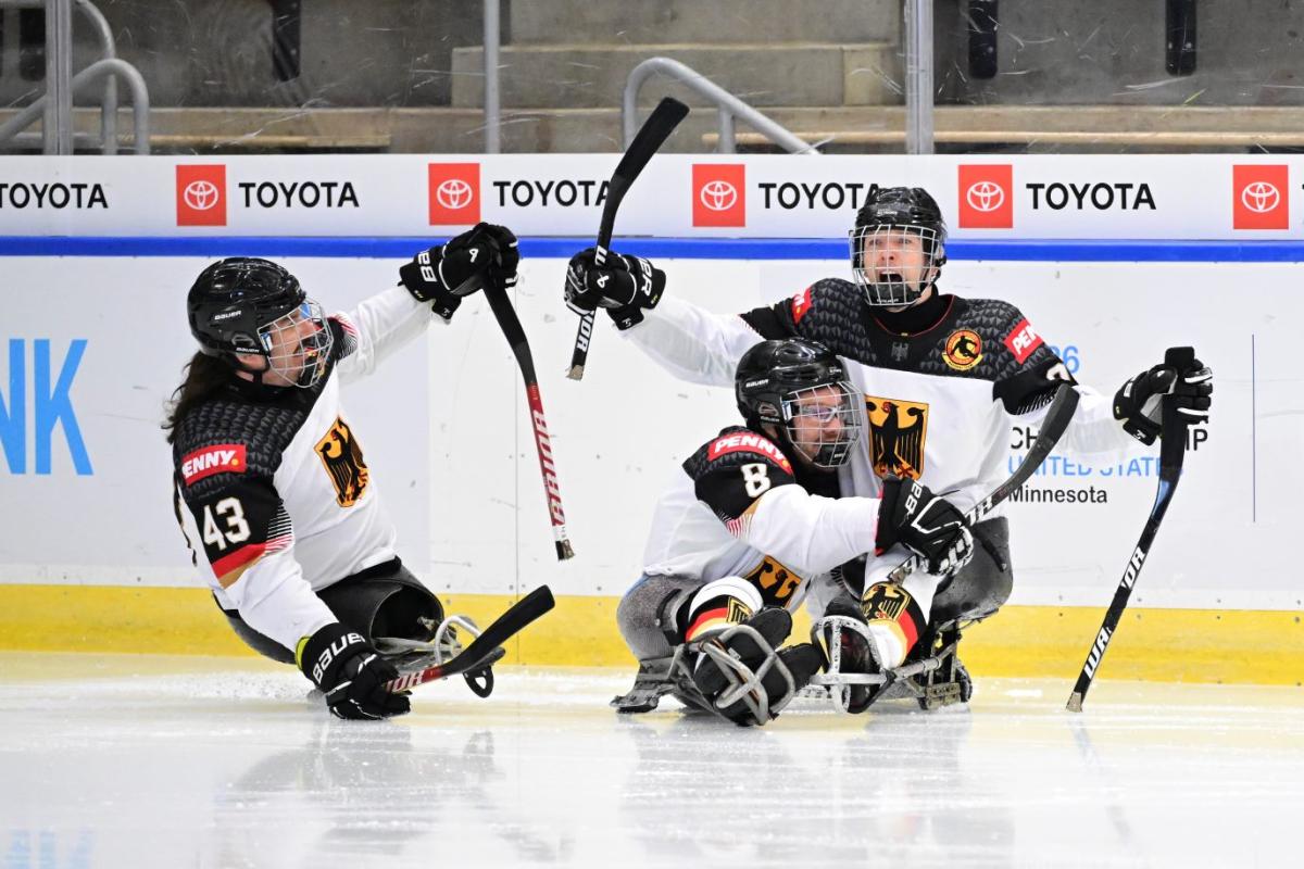 Three German Para ice hockey players celebrating a goal