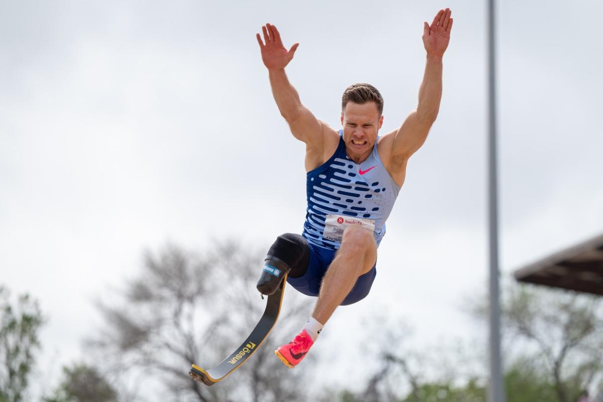 A man with a prosthetic leg competing in the long jump