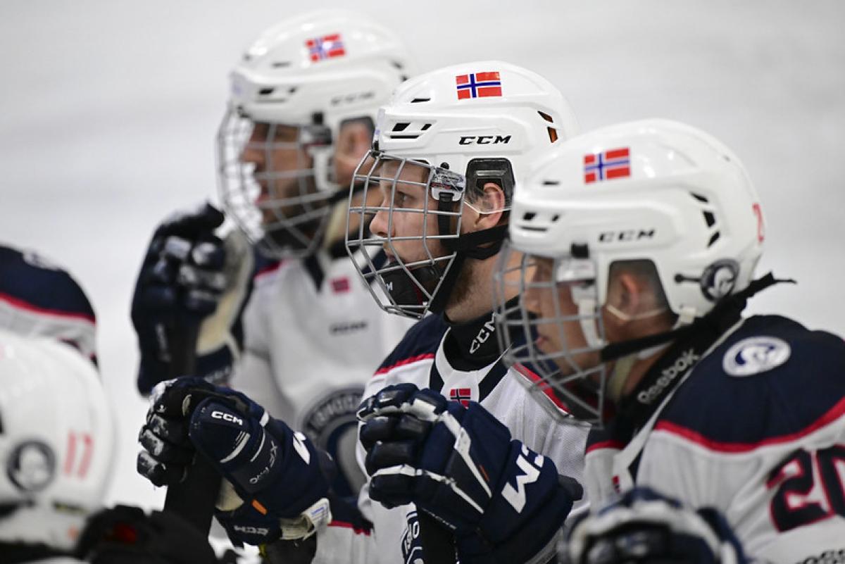 Three male Para ice hockey players looking straight