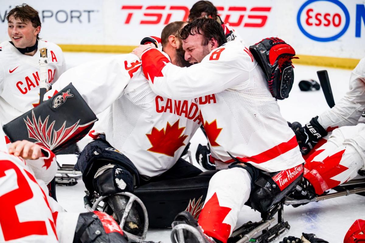 A group of Canadian Para ice hockey players celebrating on ice