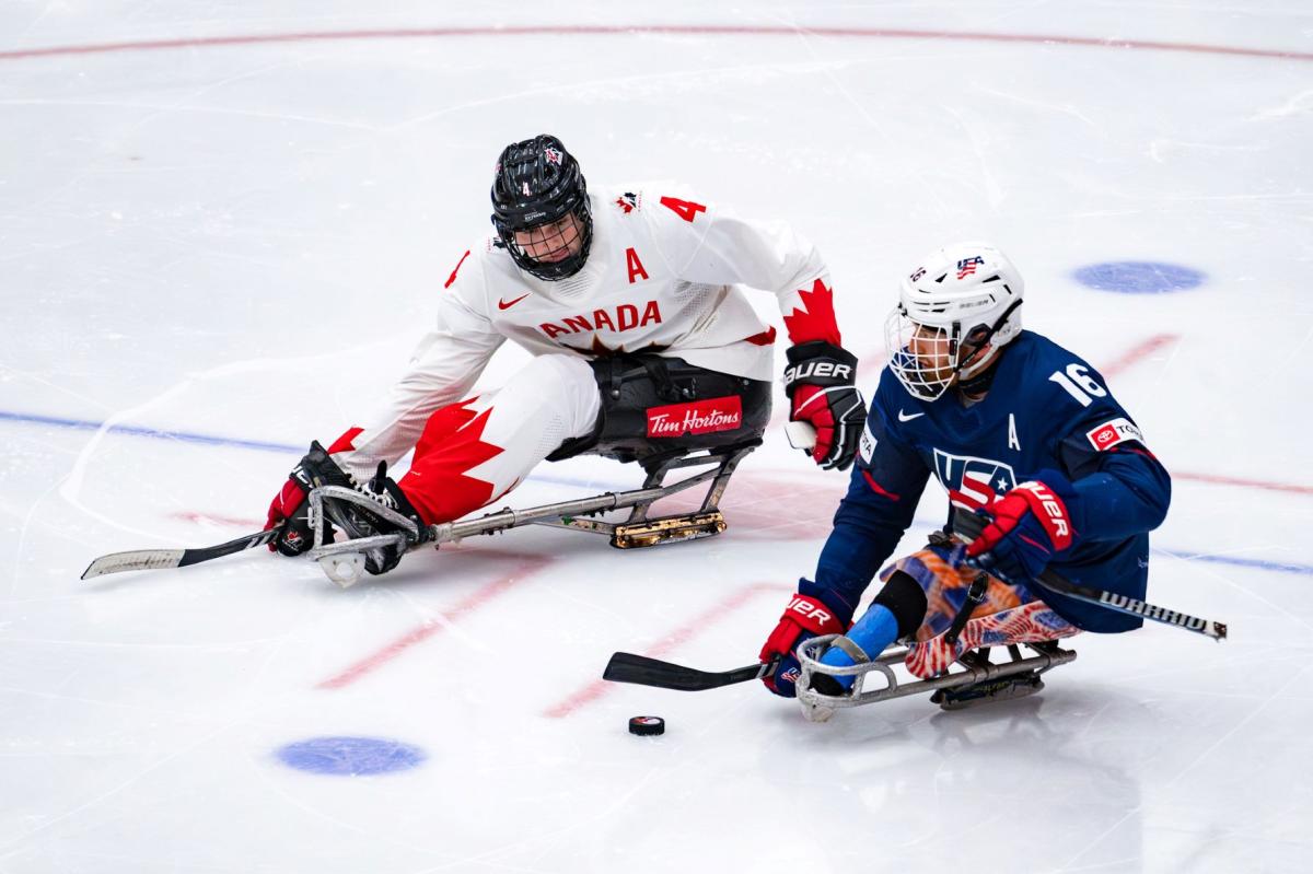 A Para ice hockey player from USA against a player from Canada