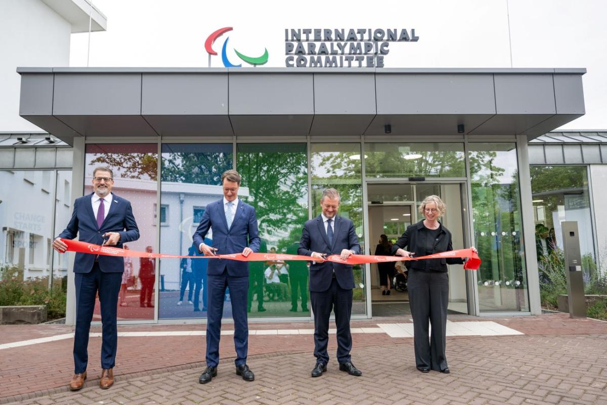 Four officials (three male and one female) cut a red ribbon in front of the new IPC Campus