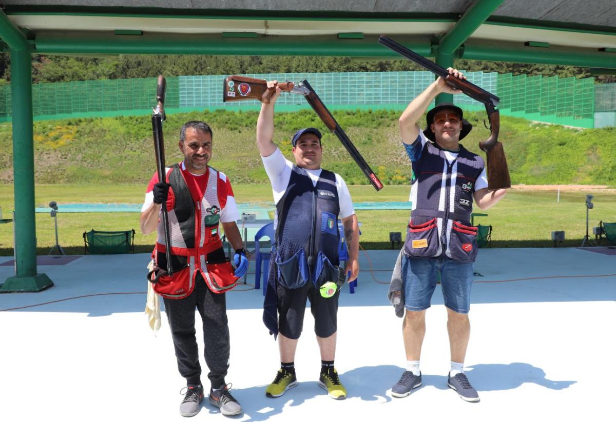 Three Para trop shooters standing with their shotguns after a competition