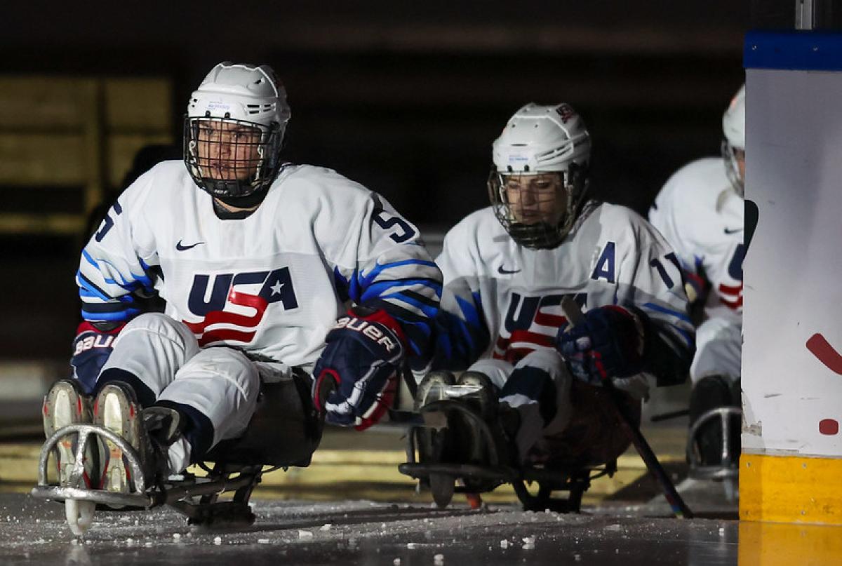 Three USA female Para ice hockey players entering the ice rink