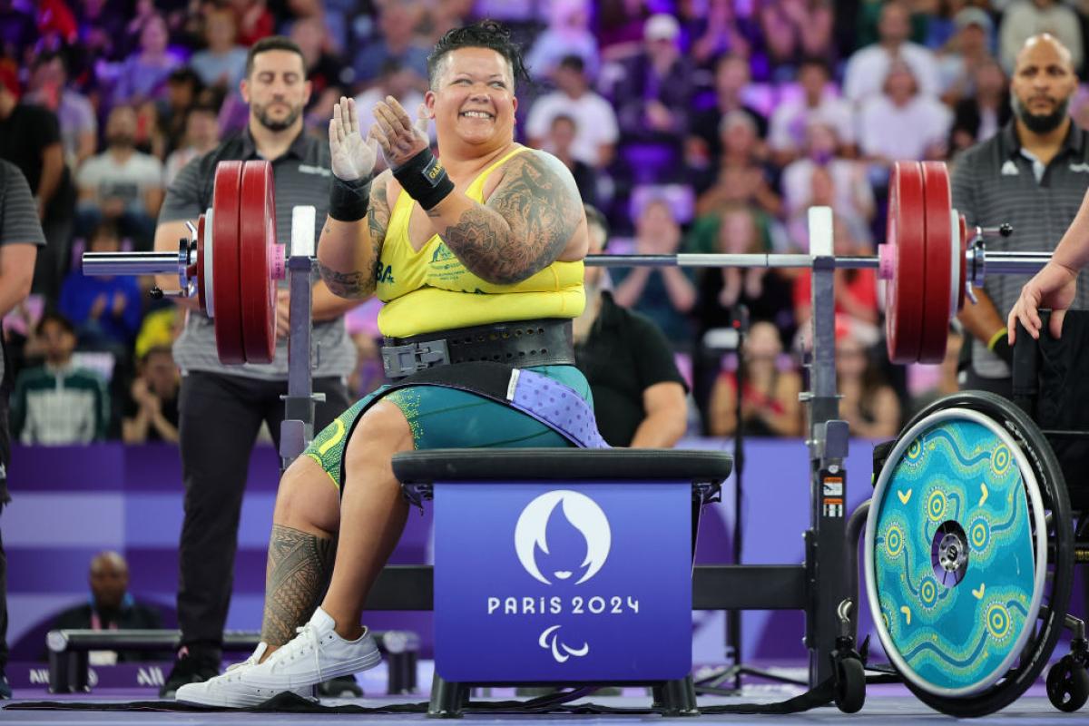 A female powerlifter clapping hands on the bench press at Paris 2024