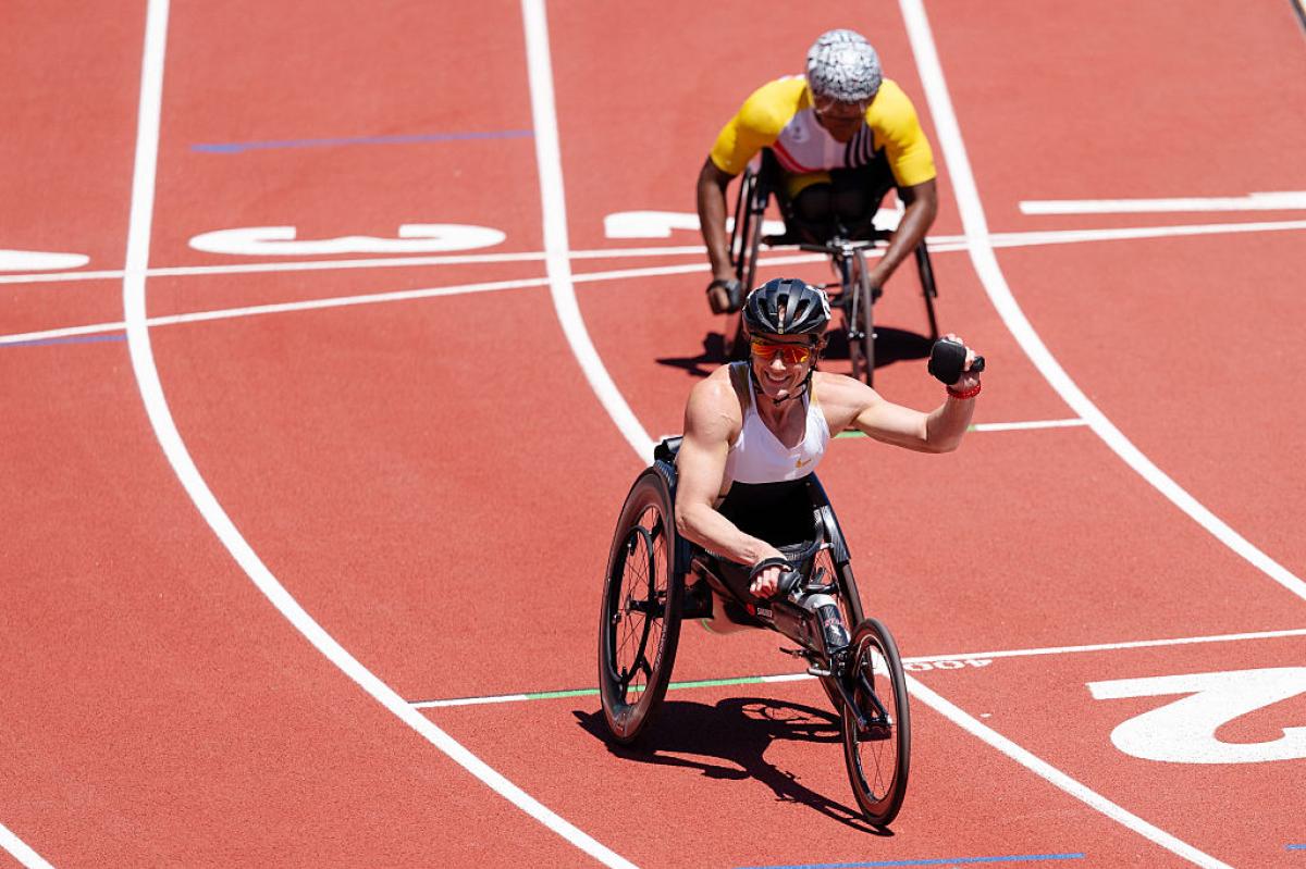 A female wheelchair racer celebrating with another racer behind her