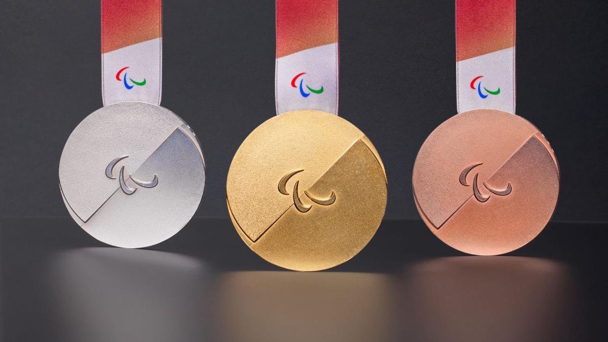 Photo of silver, gold and bronze medals - the medals have the Agitos symbol in the centre and have red ribbons