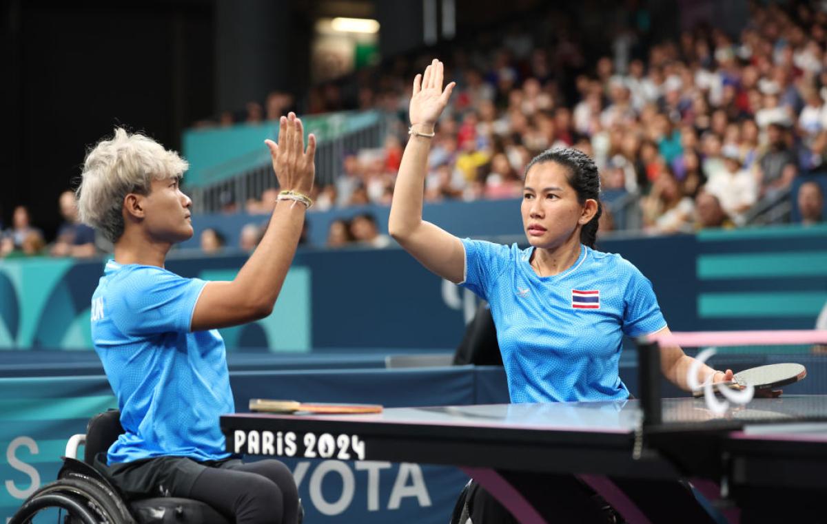 A mixed doubles Para table tennis players from Thailand do a high-five