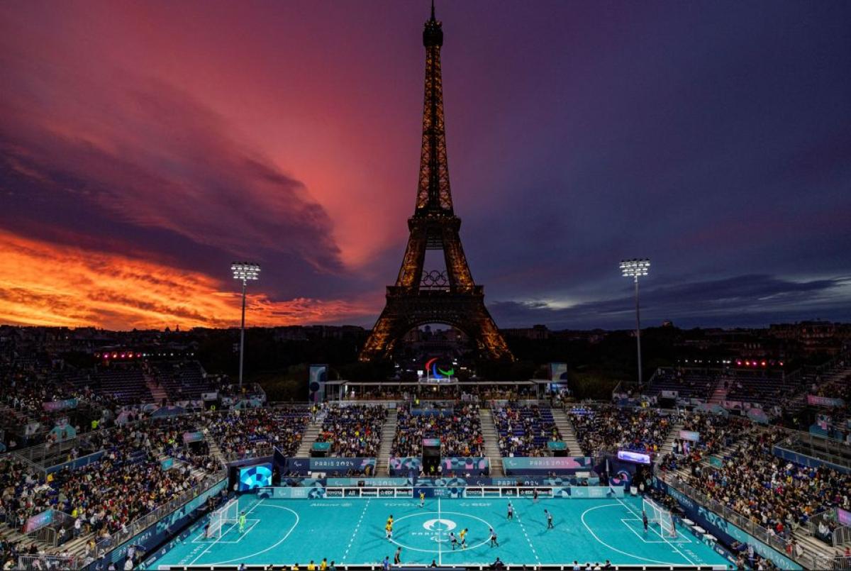 A blind football match being played under the Eiffel tower during sunset