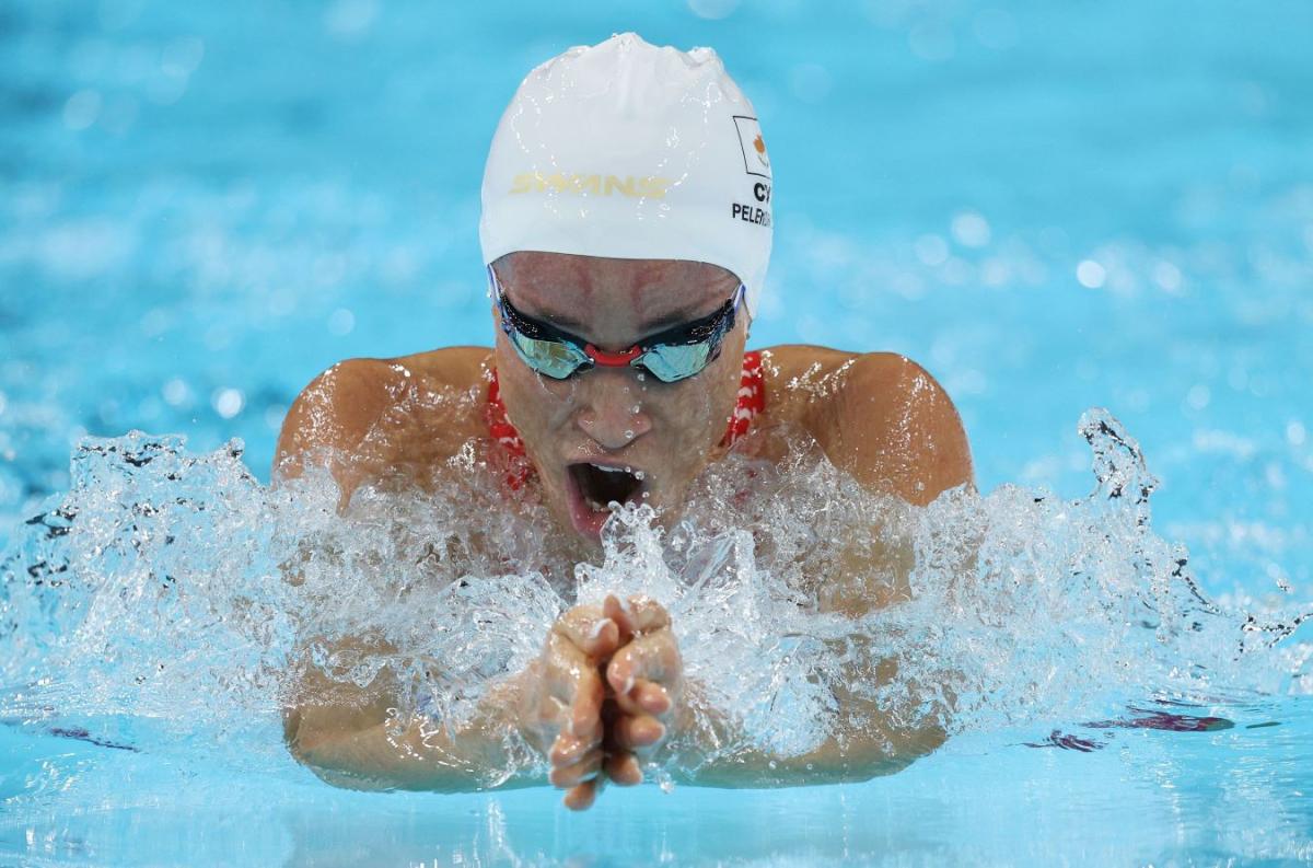 A female athlete with blackened goggles swimming breaststroke