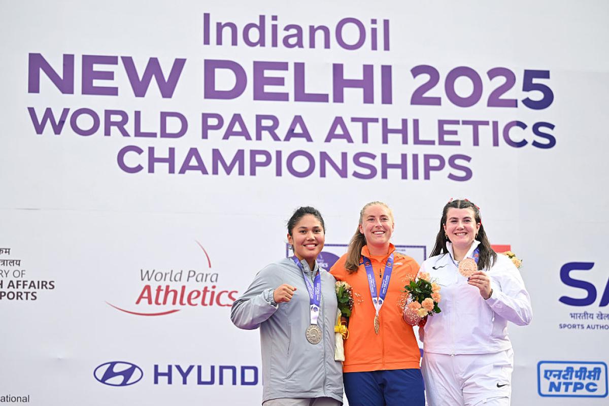 Three women showing their medals after a competition