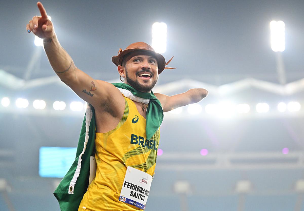 One-armed Para athlete with the Brazilian flag around his shoulders