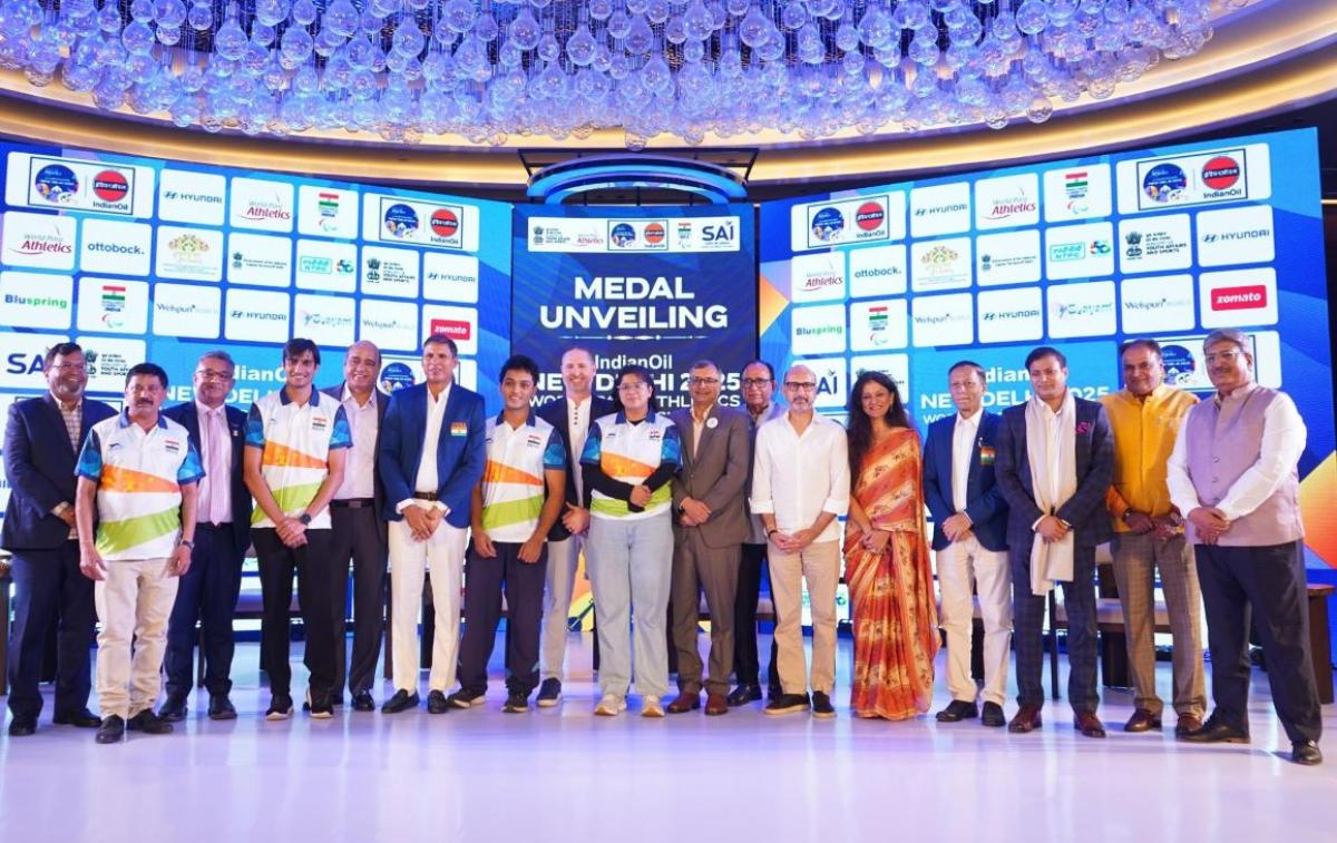 A group of people on a stage showing medals