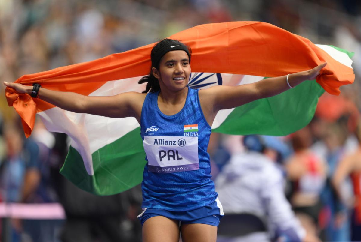 A female Para athlete is holding the Indian flag to celebrate