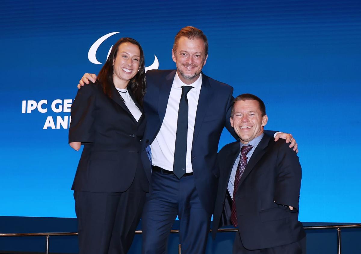 IPC President Andrew Parsons, First Vice-President Leila Marques Mota and Second Vice-President John Petersson pose for a picture at the IPC General Assembly Seoul 2025