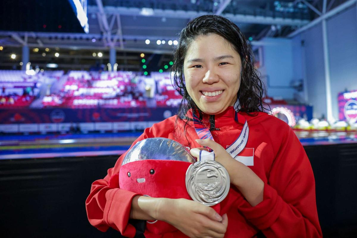 An athlete shows her medal 