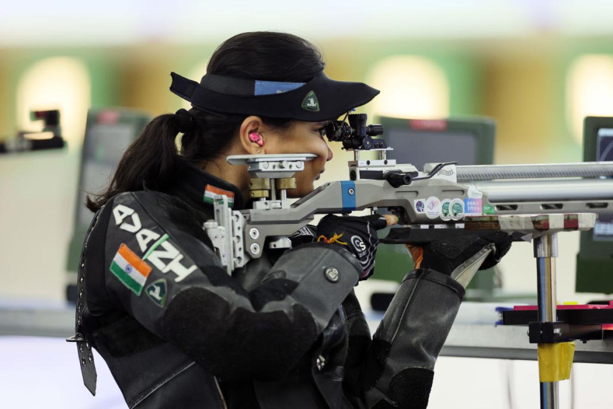 A female rifle shooter competing in a shooting range