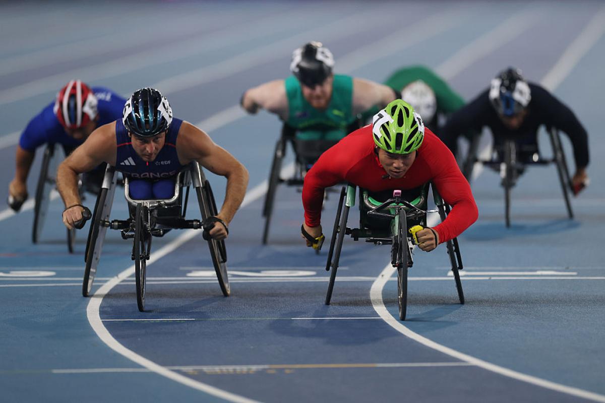 Six male wheelchair racers in a competition