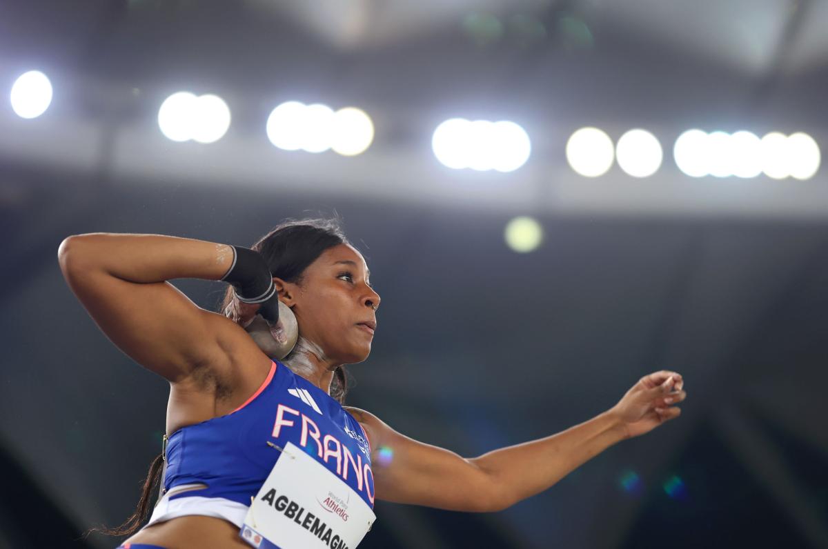 A female athlete competing in the shot put