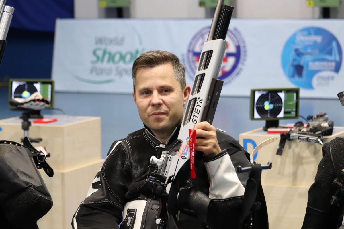 A shooting athlete with his rifle in a competition