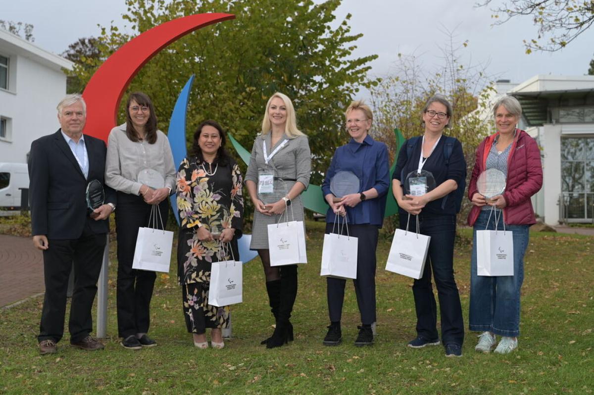 Recipients of the IPC 2025 Classification Recognition Award pose in front of the Agitos.